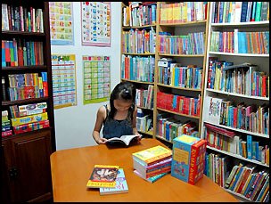 A Primary 5 student enjoys some reading time from the mini library in my teaching room.